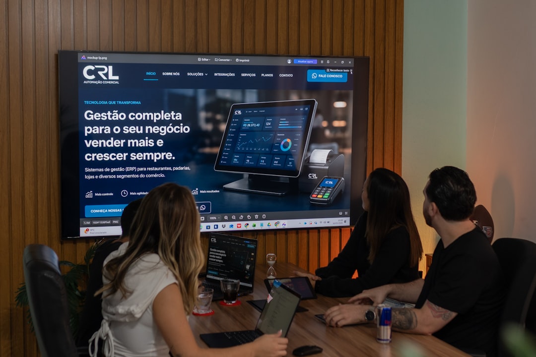 Three colleagues viewing a business presentation on a large screen. — Foto: Rodrigo Rodrigues | WOLF Λ R T / Unsplash